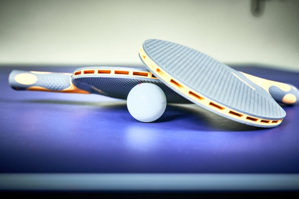 Tischtennisplatte mit Ball und Tischtenniskellen Tischtennisplatte mit Ball und Tischtenniskellen